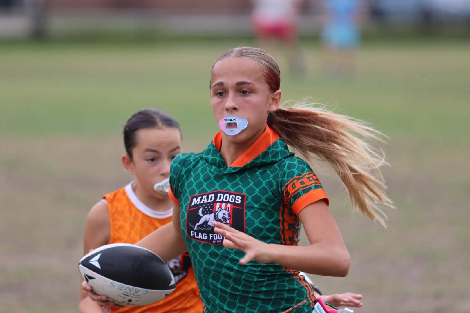 Mad Dogs girls flag football player running with the ball